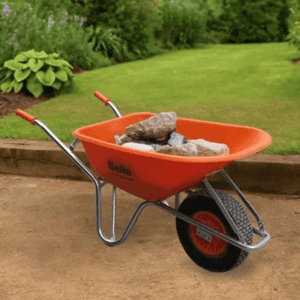 Agricultural hand tools and a wheelbarrow in a garden